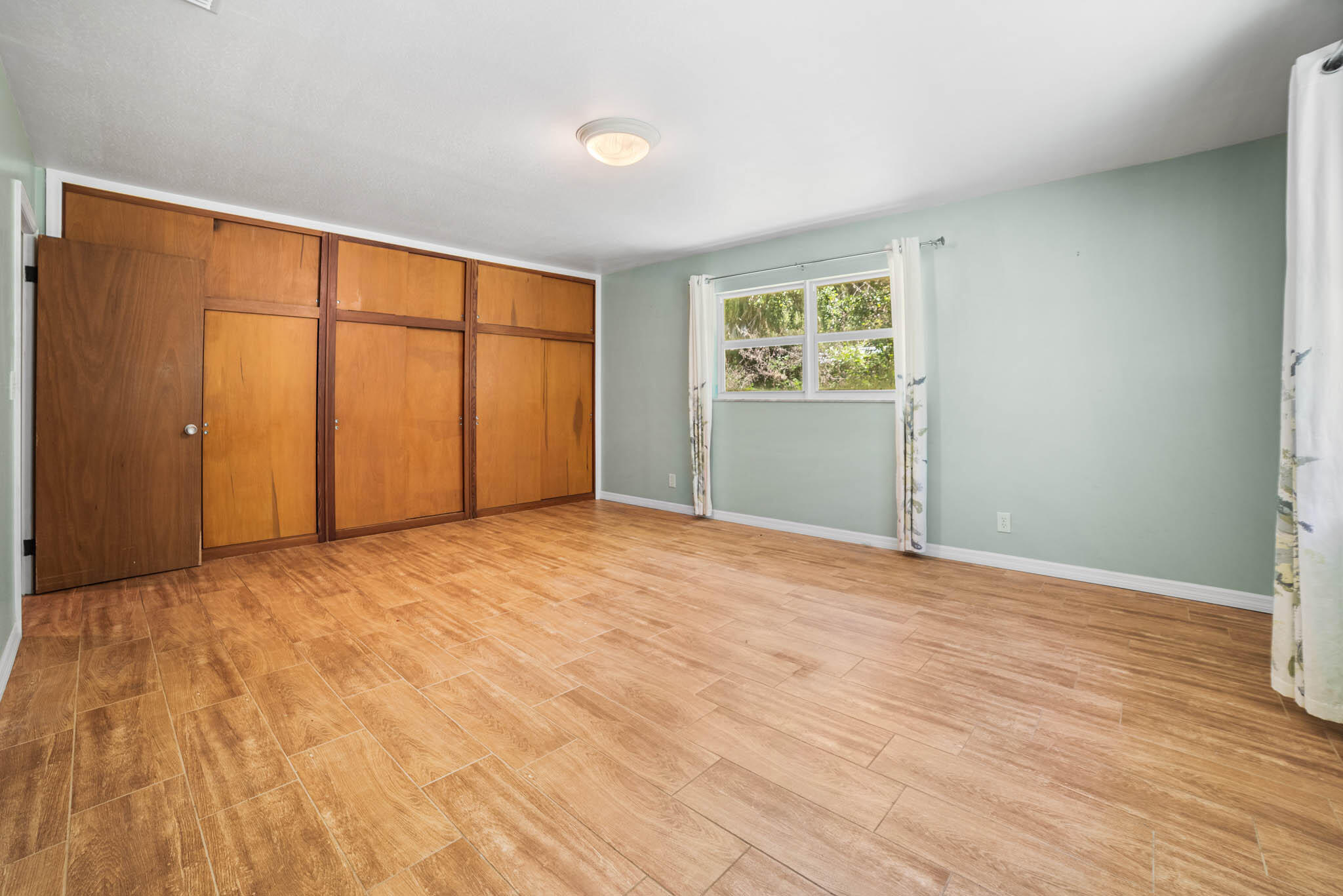 409 Southwest 15th Street Okeechobee, FL 34974 - Photo 12 of 14 a view of an empty room with wooden floor and a window