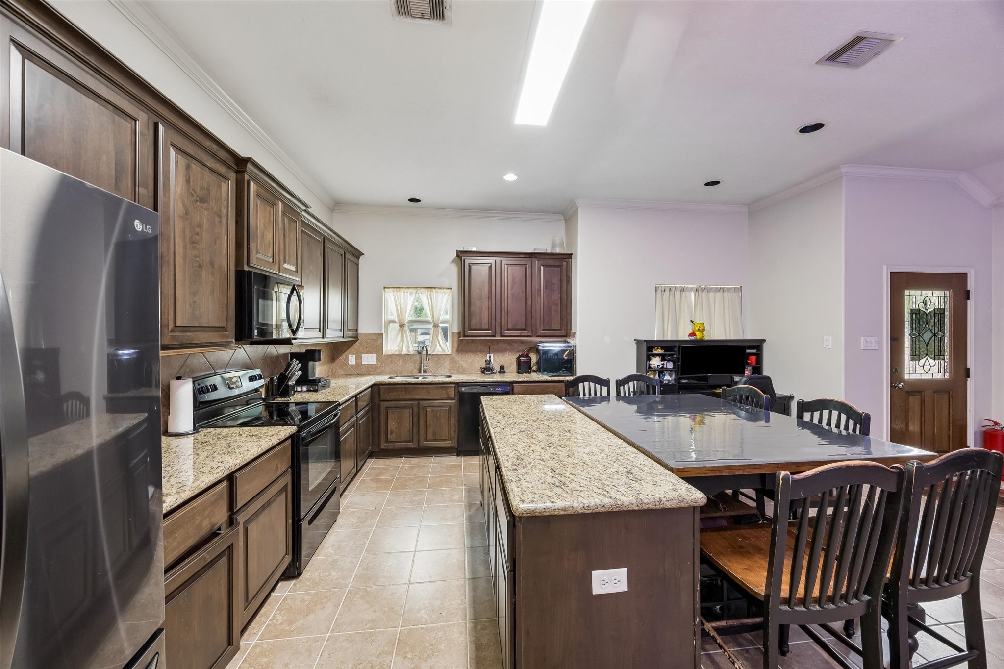 1741 Eagle Lake Road Sealy, TX 77474 - Photo 4 of 15 a kitchen with granite countertop kitchen island wooden cabinets a sink stove and refrigerator