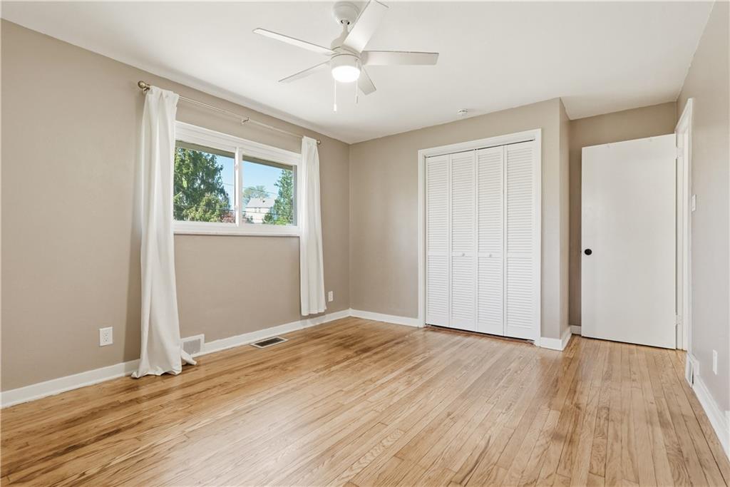 4940 3rd Street Verona, PA 15147 - Photo 20 of 27 an empty room with wooden floor chandelier fan and windows