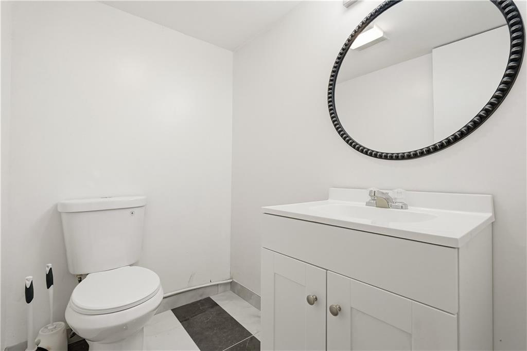 4940 3rd Street Verona, PA 15147 - Photo 24 of 27 a bathroom with a toilet a sink and a mirror