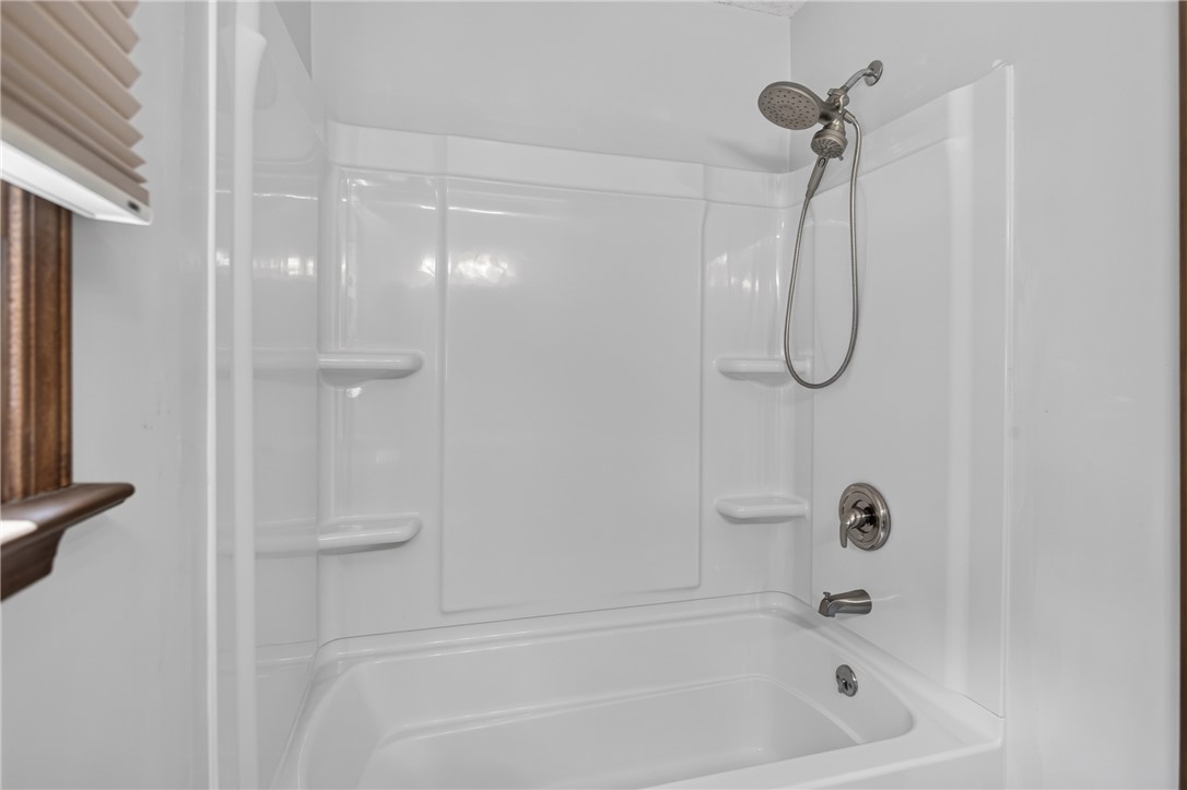 103 Dorsey Lane Walhalla, SC 29691 - Photo 18 of 42 A well-maintained tub and shower combination with convenient shelving.