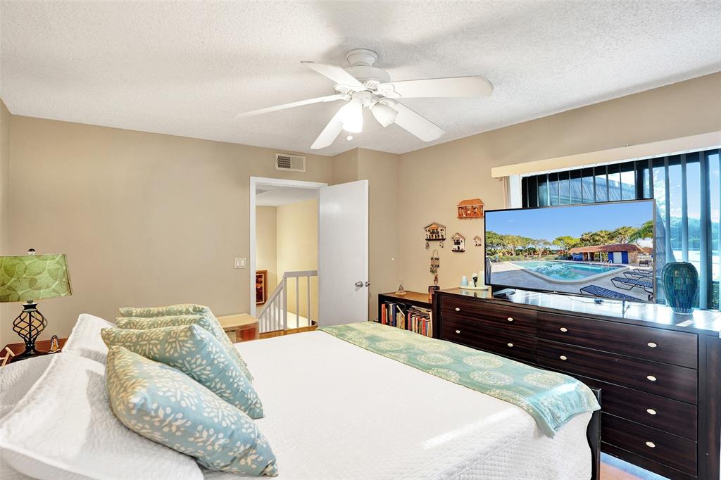 1525 Augusta Circle, Unit 109 Delray Beach, FL 33445 - Photo 17 of 23 a bedroom with a bed and a flat screen tv
