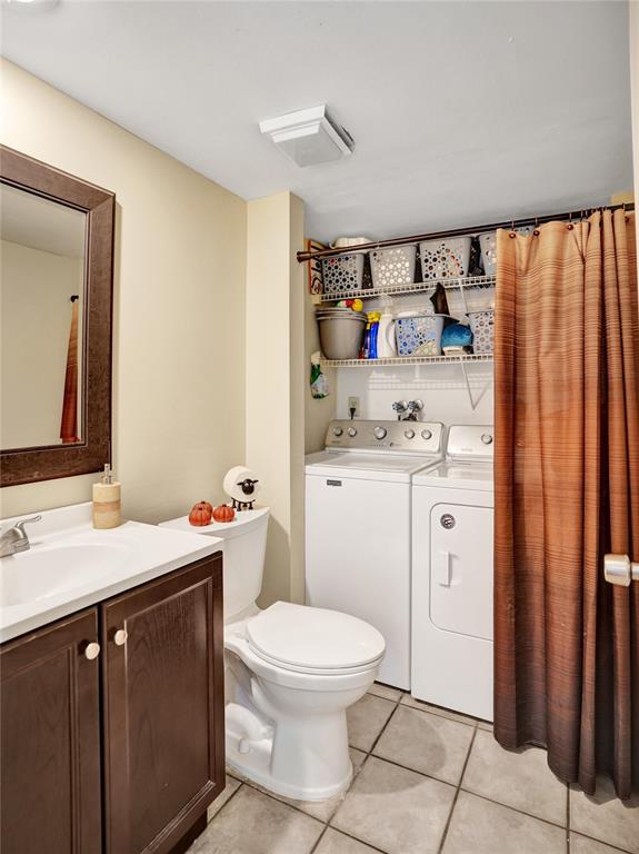 1525 Augusta Circle, Unit 109 Delray Beach, FL 33445 - Photo 19 of 23 a bathroom with a sink a toilet and a mirror