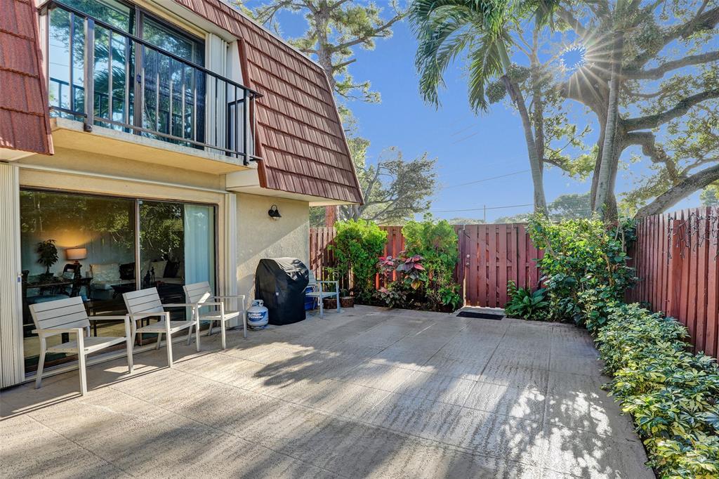 1525 Augusta Circle, Unit 109 Delray Beach, FL 33445 - Photo 20 of 23 a view of a chairs and tables in patio