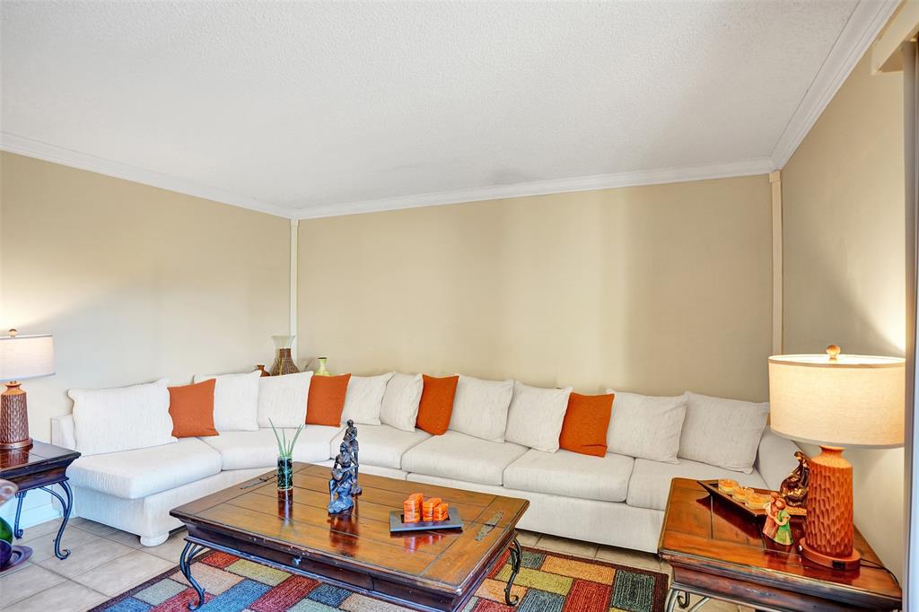 1525 Augusta Circle, Unit 109 Delray Beach, FL 33445 - Photo 5 of 23 a living room with a couch and a coffee table