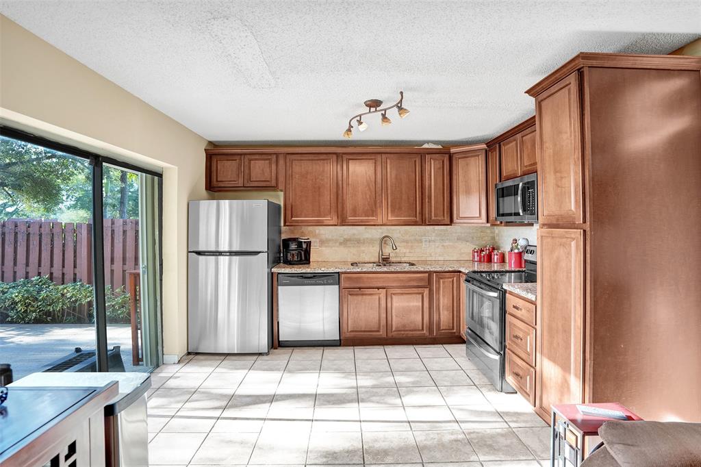 1525 Augusta Circle, Unit 109 Delray Beach, FL 33445 - Photo 8 of 23 a kitchen with refrigerator and cabinets