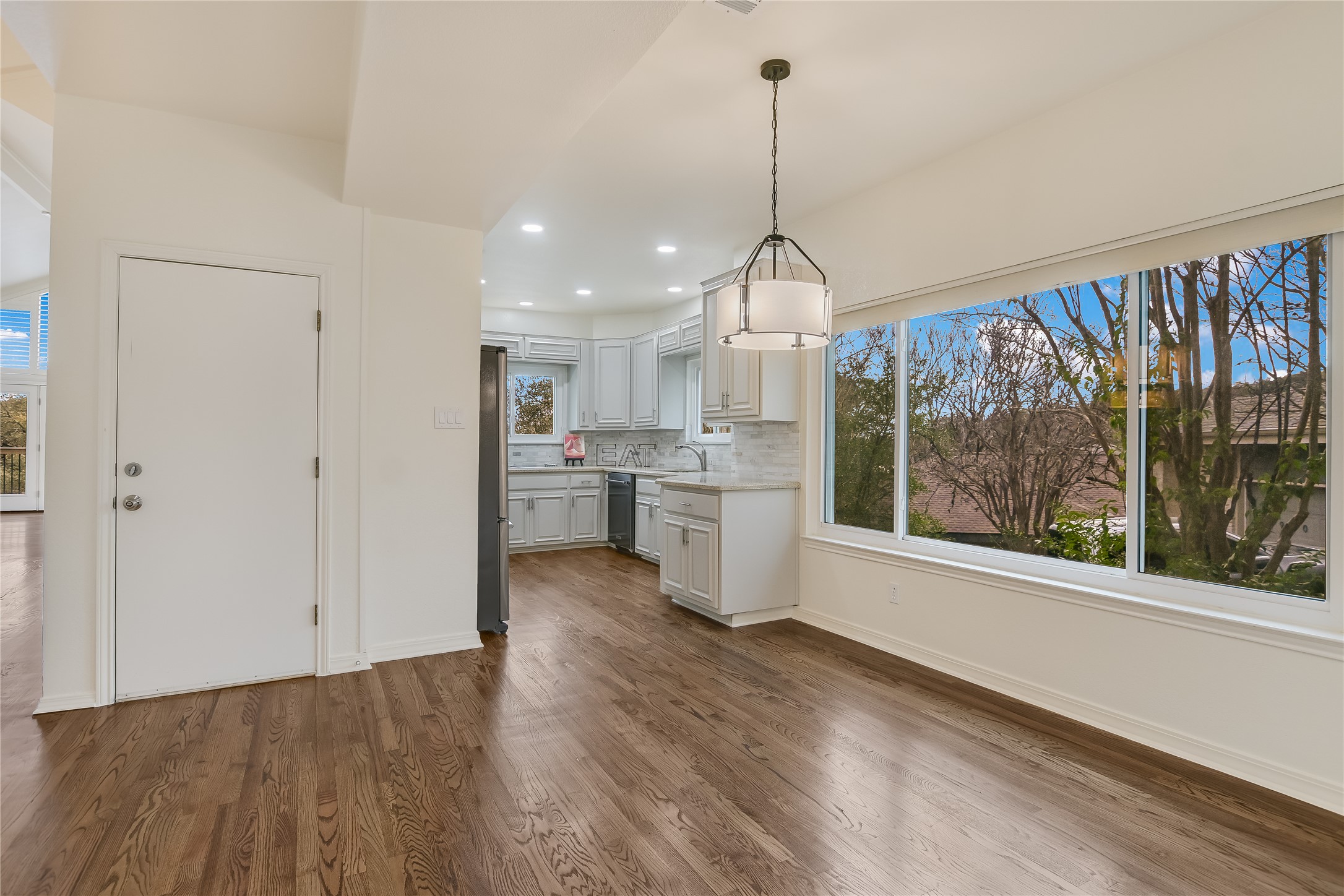 4906 Bob Cat Run Austin, TX 78731 - Photo 13 of 40 a view of a kitchen with a sink wooden floor and a large window