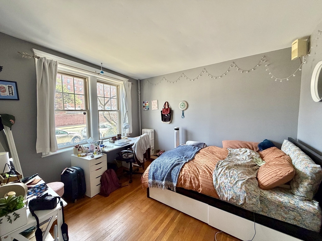 335 South Huntington Avenue, Unit 1 Boston, MA 02130 - Photo 8 of 11 a bedroom with a bed and wooden floor