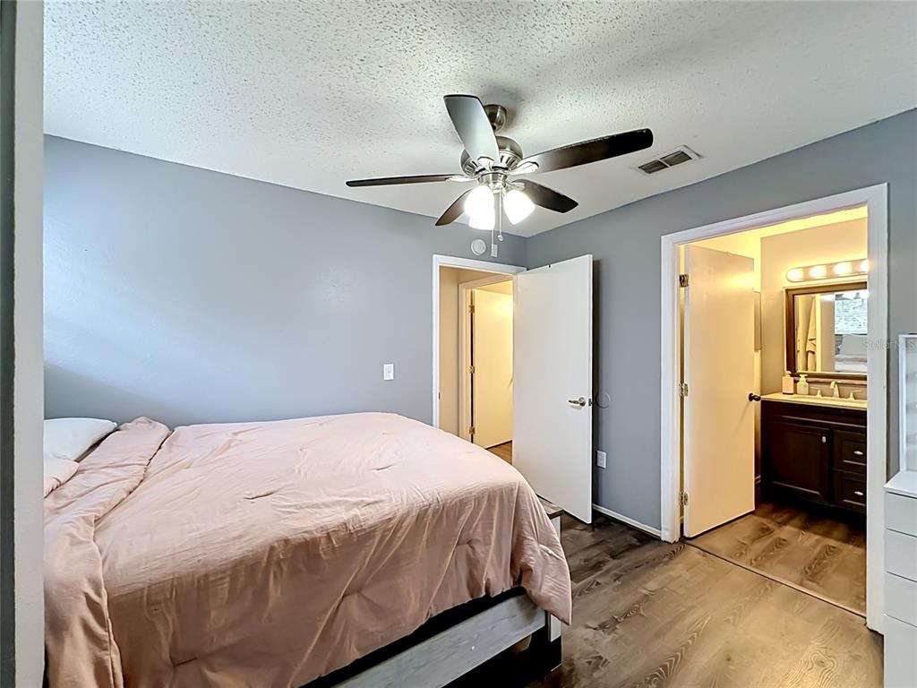 3705 Southwest 27th Street, Unit 922 Gainesville, FL 32608 - Photo 16 of 34 a bedroom with a large bed and a chandelier