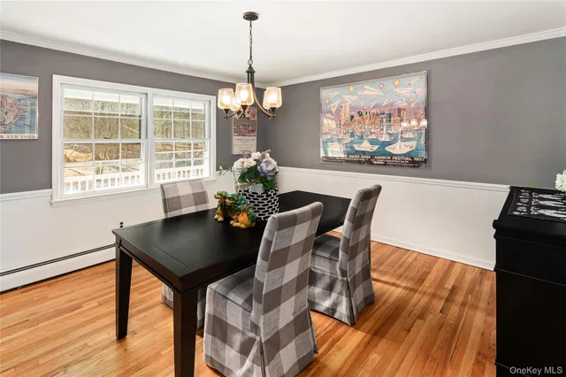 a view of a dining room with furniture a chandelier and wooden floor