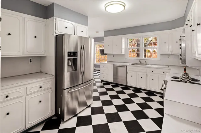 a kitchen with white cabinets and a refrigerator