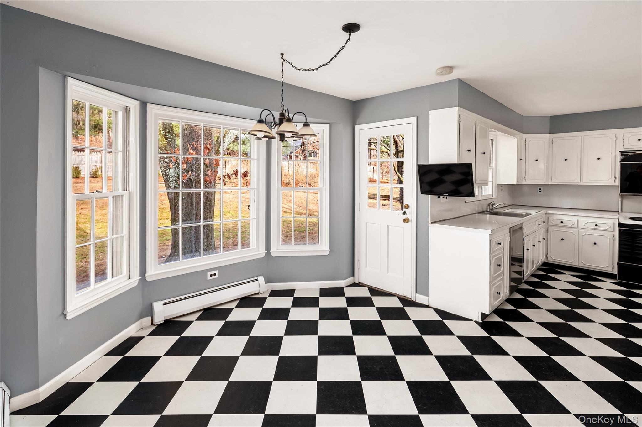 58 Millbrook Road Bedford, NY 10506 - Photo 16 of 41 a kitchen with a checkered floor and white cabinets