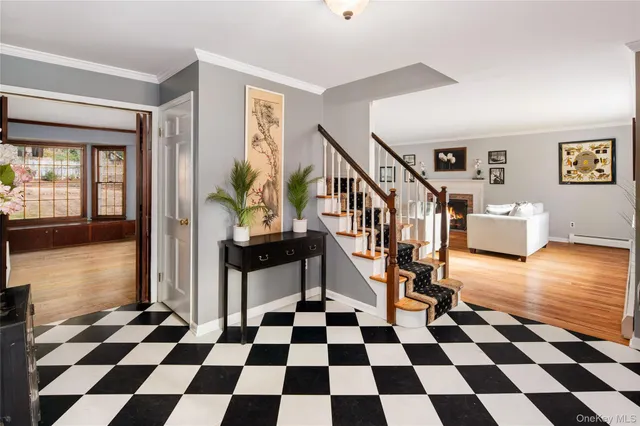 a living room with a black white checkered floor with a gaming machine and stainless steel appliances