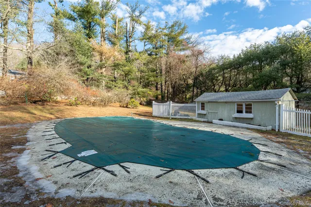 a view of pool with seating area and trees around