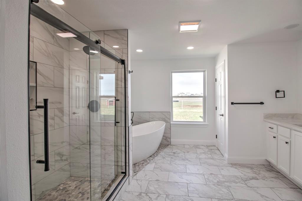 3884 Lois Road East Sanger, TX 76266 - Photo 31 of 40 a spacious bathroom with a bathtub shower and sink