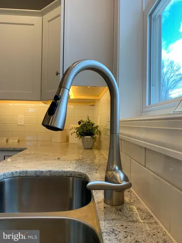 a kitchen with stainless steel appliances kitchen island granite countertop a sink a stove and a refrigerator