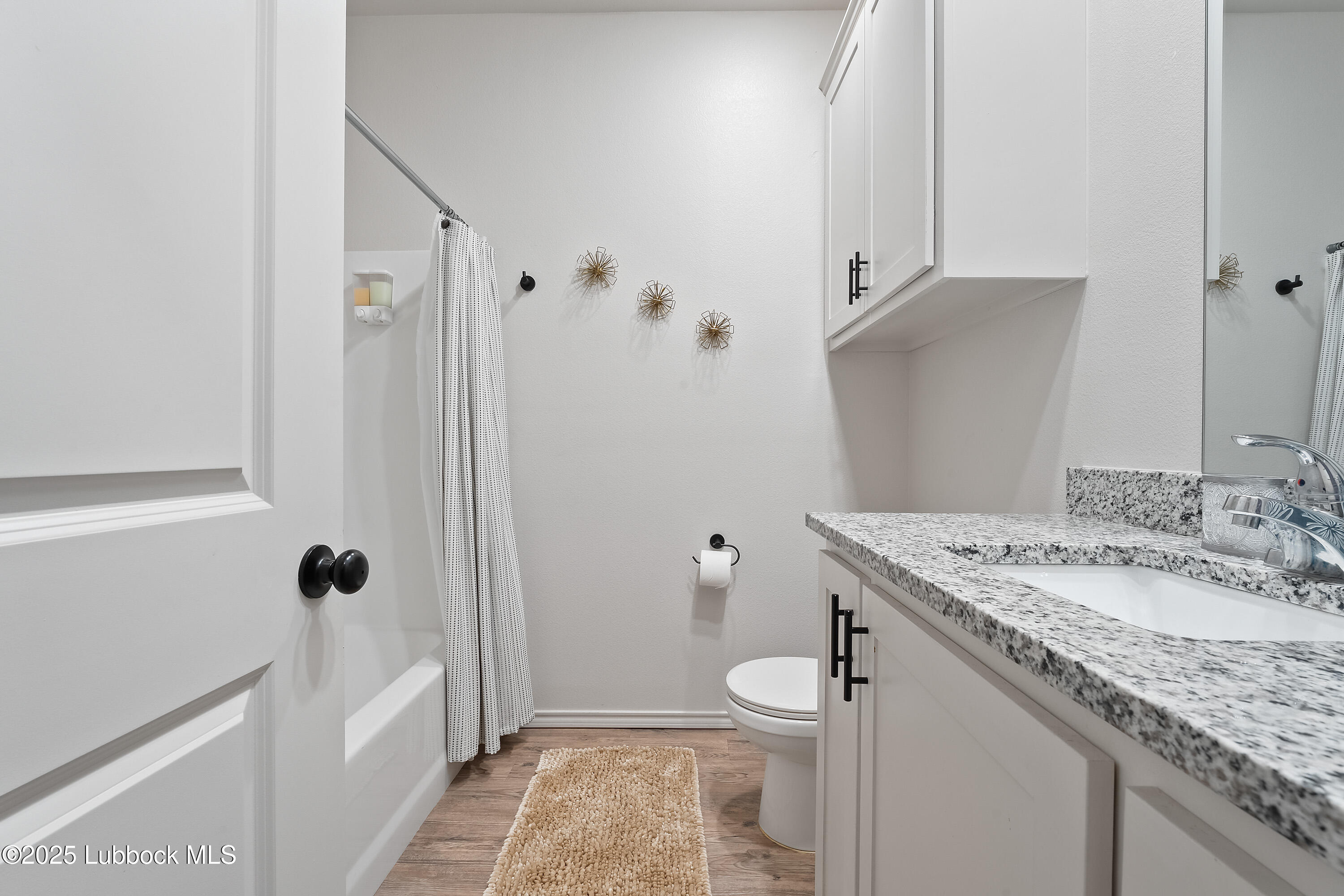 5528 Lehigh Street Lubbock, TX 79416 - Photo 17 of 23 a bathroom with a granite countertop sink a toilet and shower