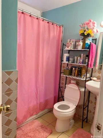 a white toilet sitting next to a shower curtain