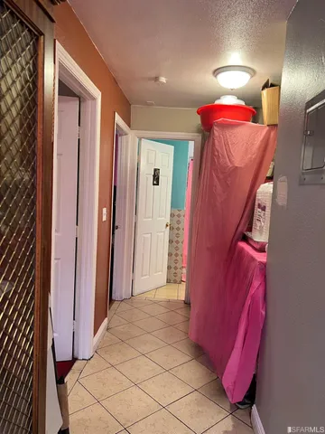 a view of a hallway with bathroom and a mirror