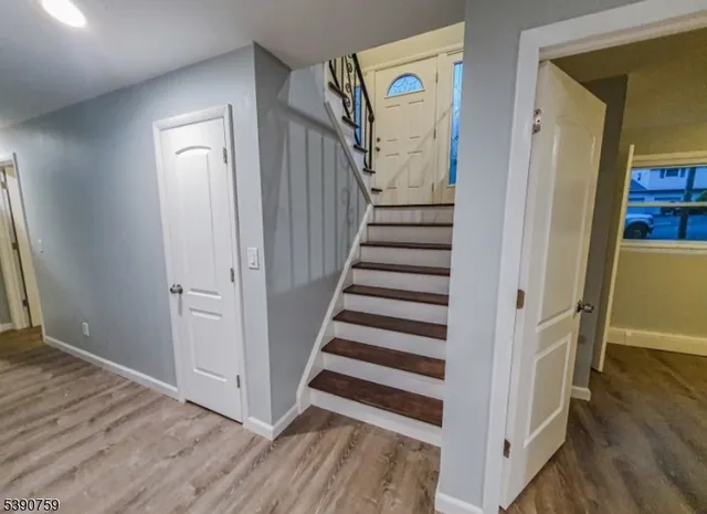 a view of a hallway with wooden floor and entryway