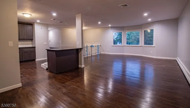 an open kitchen with kitchen island a sink dishwasher stove and wooden floor