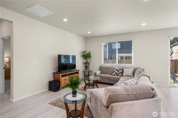 a living room with furniture a flat screen tv and a window