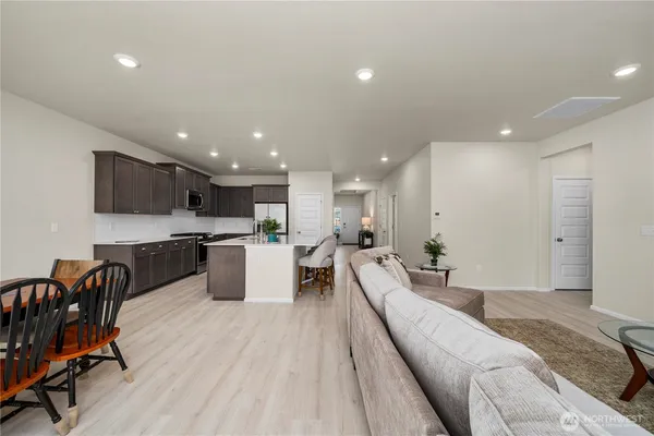 a large living room with stainless steel appliances kitchen island granite countertop a large kitchen island a stove a sink a refrigerator and a couch