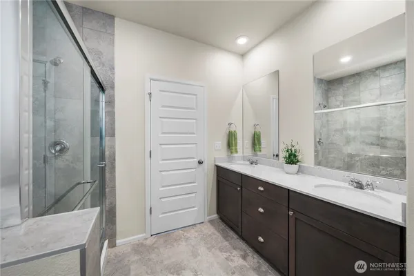 a bathroom with a double vanity sink mirror and shower