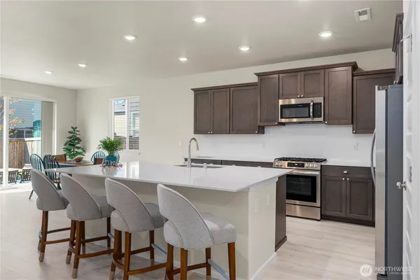 a kitchen with kitchen island a stove a table and chairs