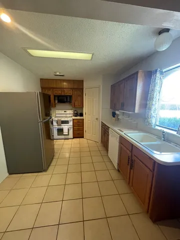 a kitchen with a sink a stove top oven and cabinets