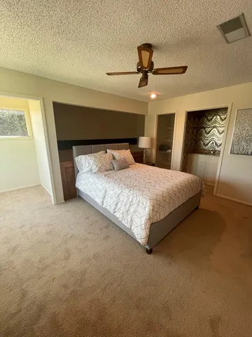 a bedroom with a large bed and a ceiling fan