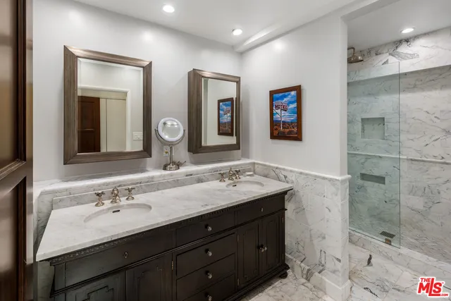 a bathroom with double sink and a mirror