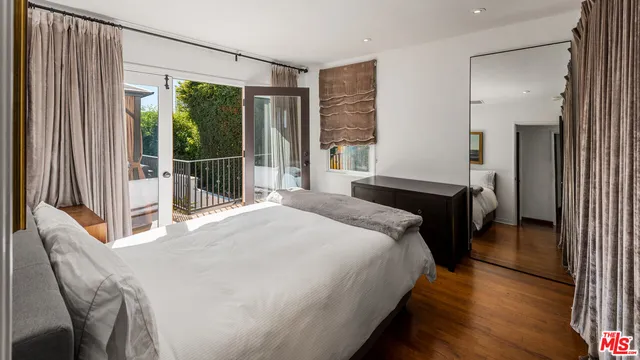 a bedroom with a bed and a large window