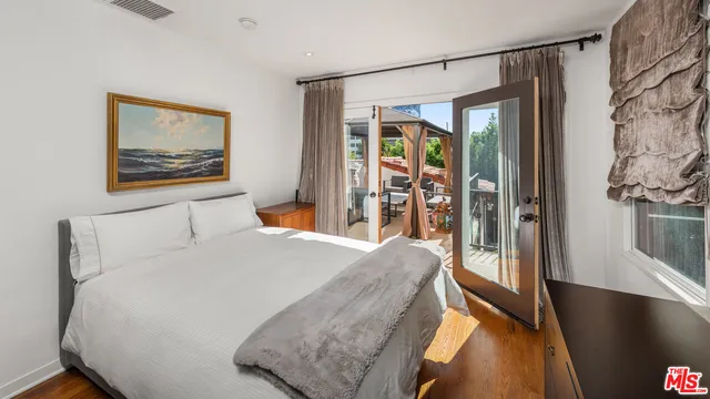 a bedroom with a large bed and a painting on the wall