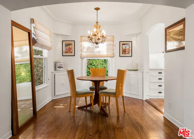 a dining room with furniture a window and wooden floor