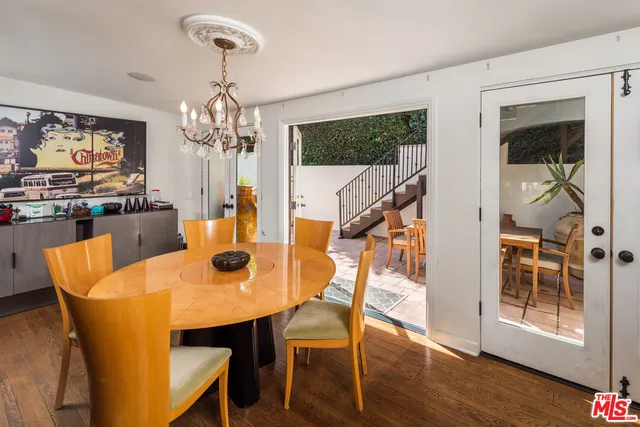 a dining room with furniture a chandelier and wooden floor