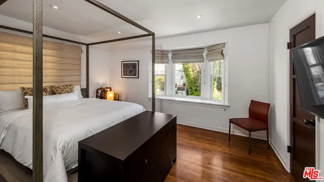 a bed room with a bed window and a television