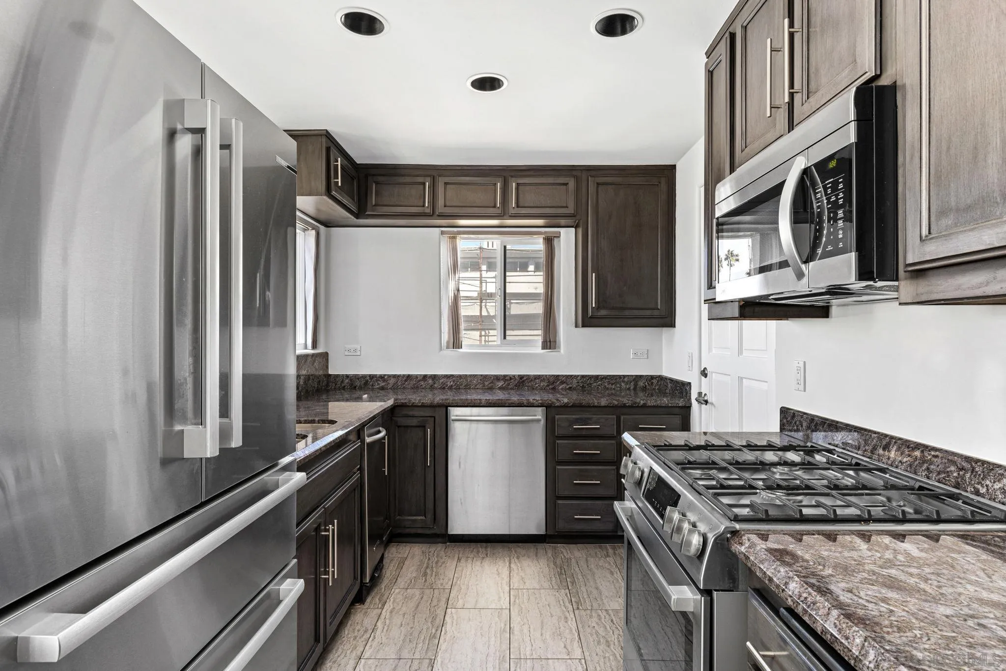 200 Pine Street, Unit 1 Oceanside, CA 92054 - Photo 11 of 28 a kitchen with stainless steel appliances granite countertop a stove a sink and a refrigerator