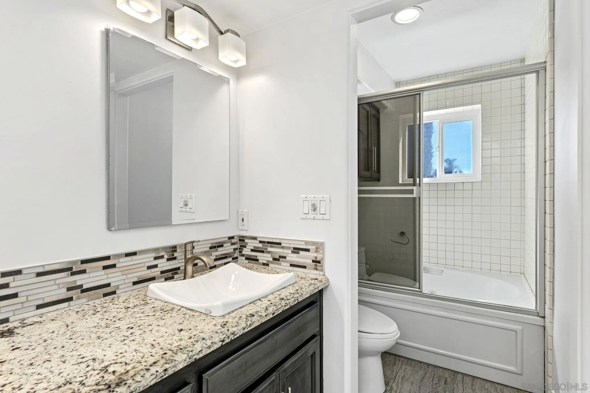 200 Pine Street, Unit 1 Oceanside, CA 92054 - Photo 16 of 28 a bathroom with a granite countertop sink a toilet and shower