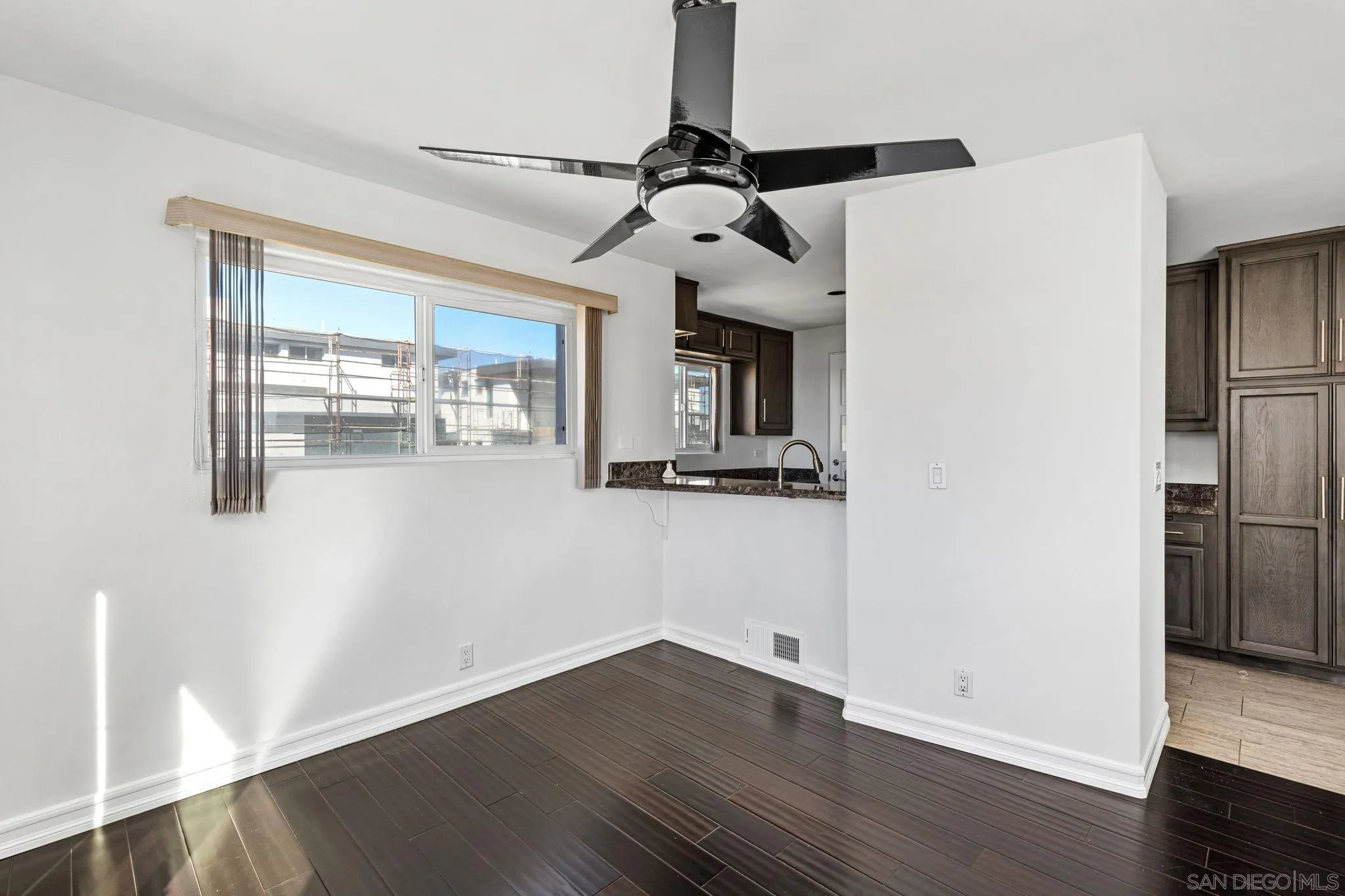 200 Pine Street, Unit 1 Oceanside, CA 92054 - Photo 9 of 28 a view of a livingroom with wooden floor a ceiling fan and kitchen space