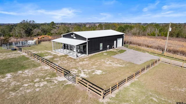 a view of a white house with a big yard