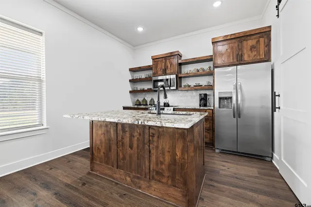 a kitchen with stainless steel appliances granite countertop a sink and a refrigerator