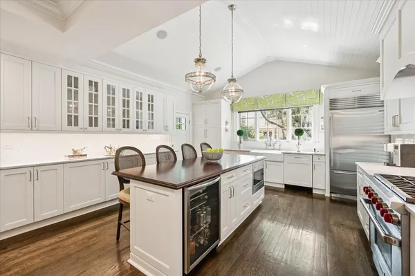 a kitchen with stainless steel appliances granite countertop a stove and white cabinets with wooden floor