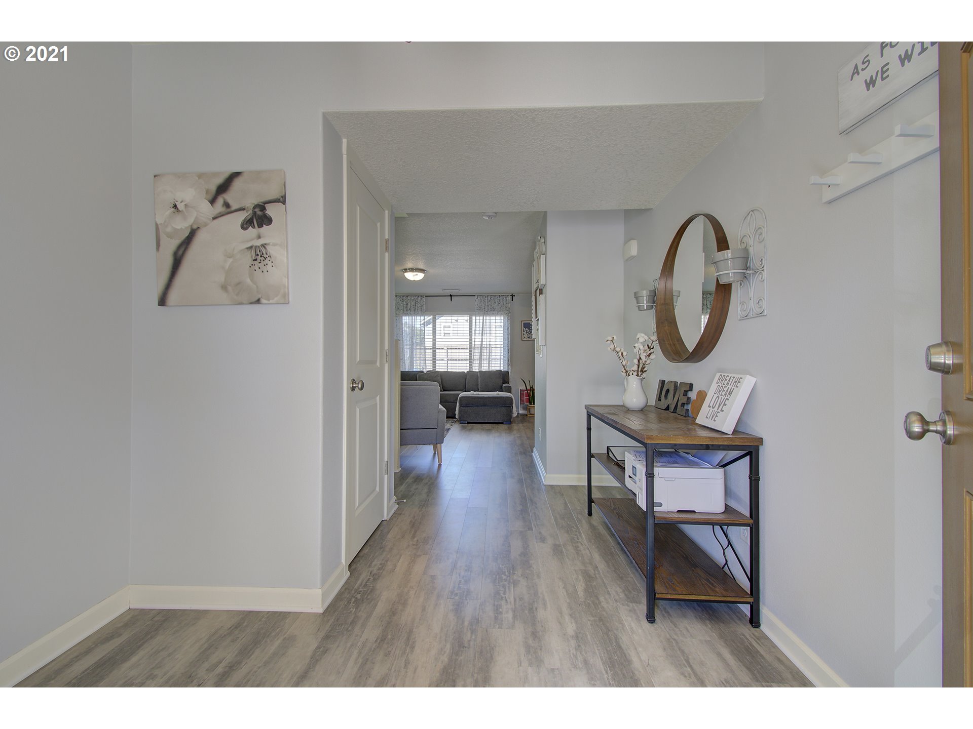 2312 South Sauk Way Ridgefield, WA 98642 - Photo 6 of 29 a view of a hallway with wooden floor and a clock on th wall