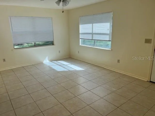 an empty room with windows and mirror