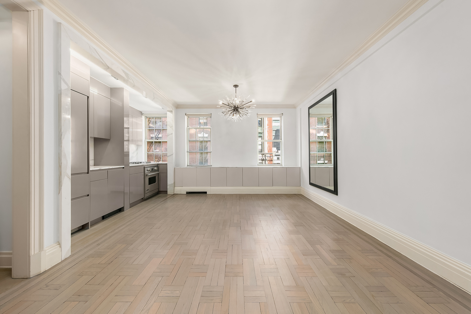 wooden floor in an empty room with a kitchen