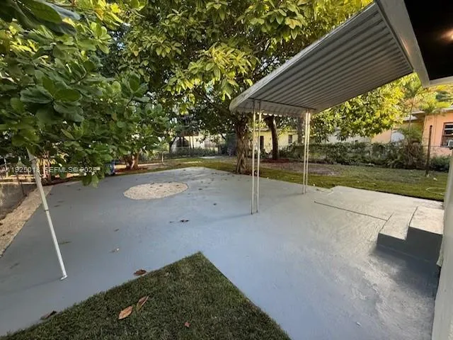 a view of a backyard with table and chairs under an umbrella