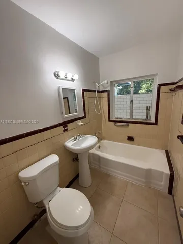 a bathroom with a sink toilet a mirror and bathtub