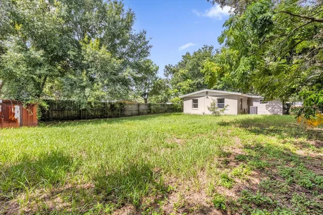 a view of a backyard with table and chairs and potted plants