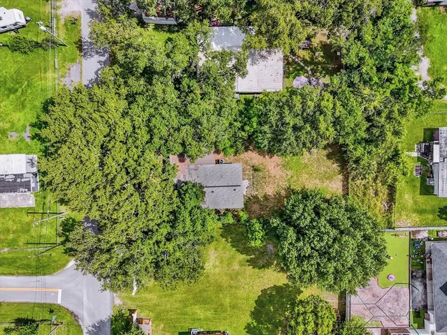an aerial view of residential houses with outdoor space and trees